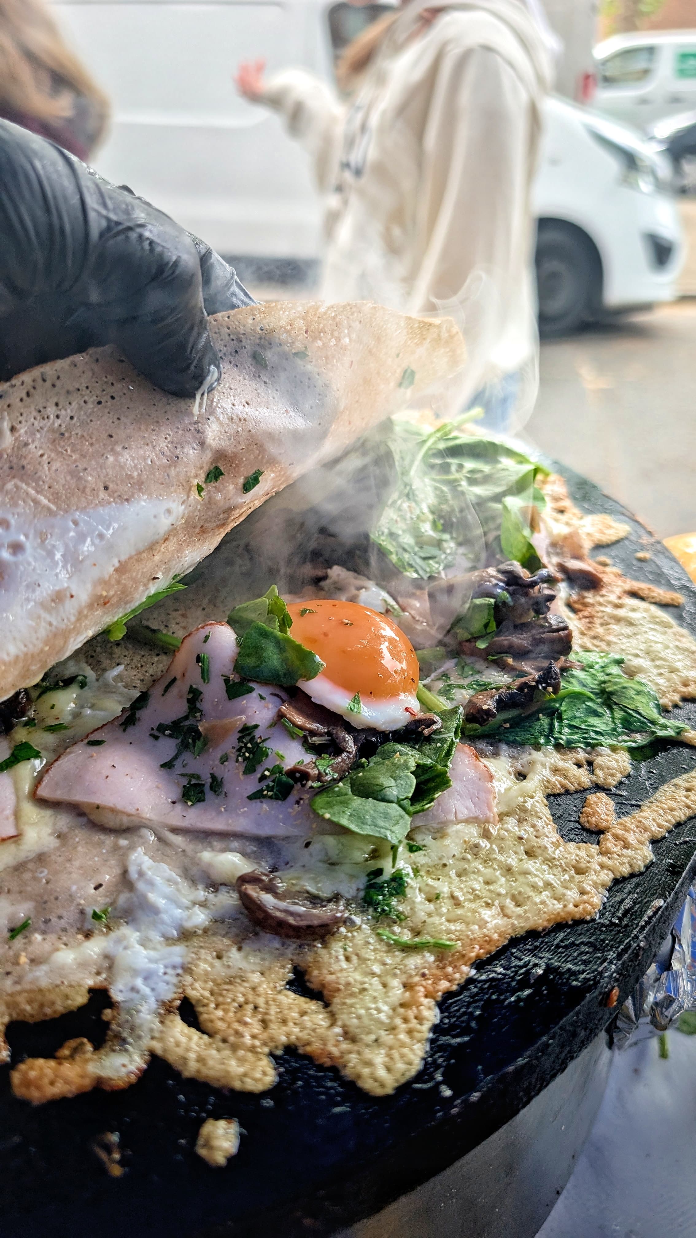 Buckwheat crêpe with poached egg, smoked ham and spinach, served live at a private event